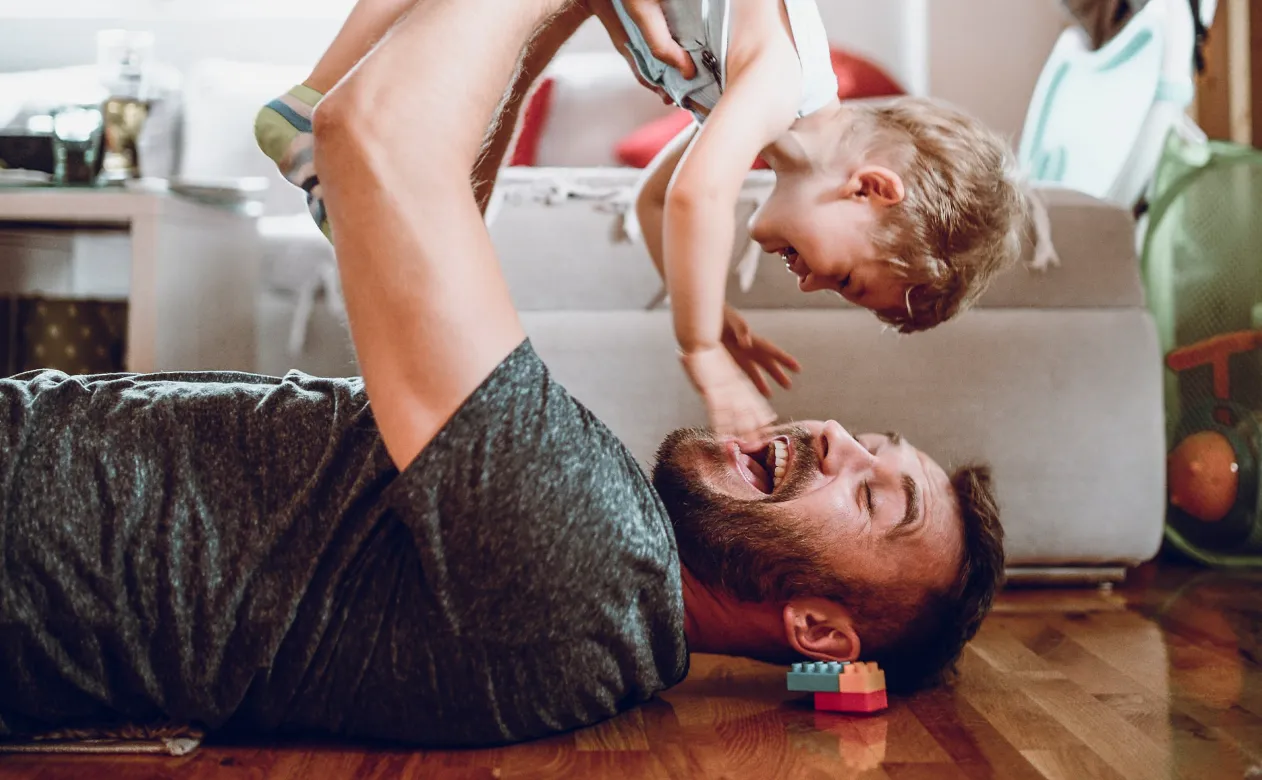 Man playing with daughter on new hardwood flooring