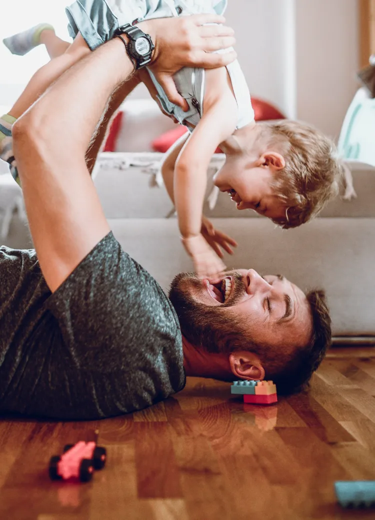 Man playing with daughter on new hardwood flooring