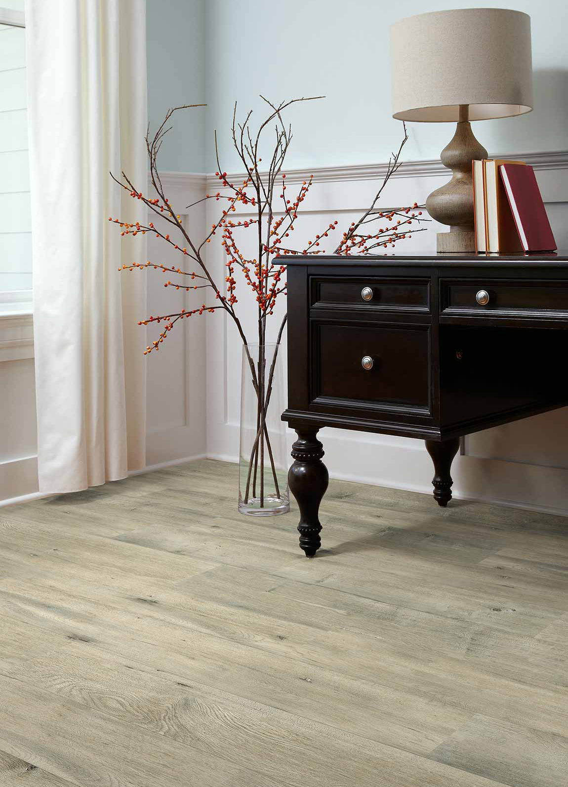 laminate by Shaw in hallway featuring floor decoration and end table with lamp and books.
